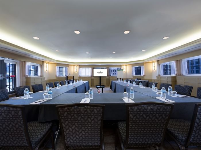 U-shaped table setup with chairs facing the projector screen in Michigan Room at Warwick Allerton Chicago