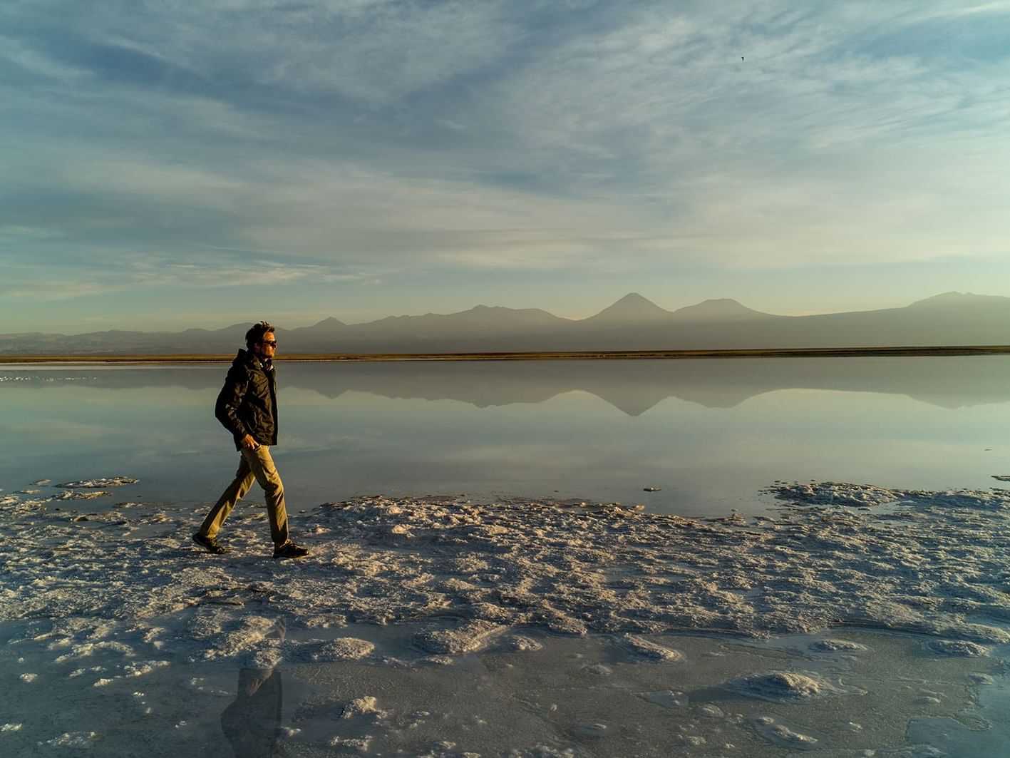 man walking in salt flats near NOI Casa Atacama Hotel