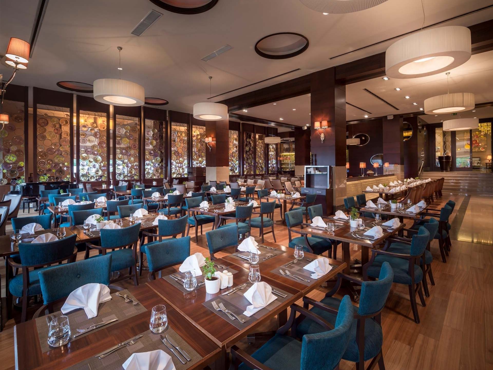 Titanic Business Kartal’daki Alesta Restaurant’ın iç mekânında, masa ve sandalyelerle düzenlenmiş yemek alanı.