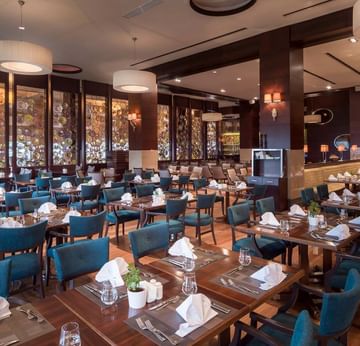 Interior of the dining area arranged with tables and chairs in Alesta Restaurant at Titanic Business Kartal