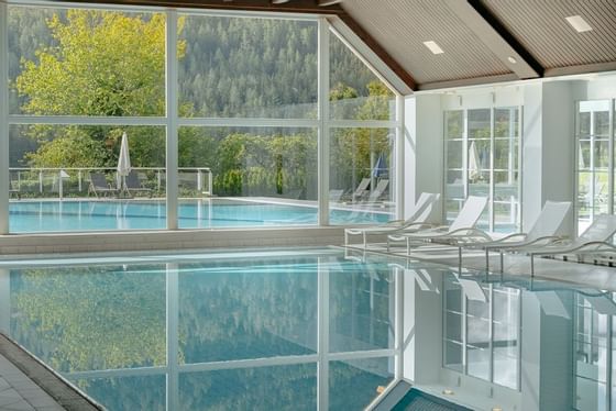 Splendid indoor pool with pool loungers at Schloss Hotel