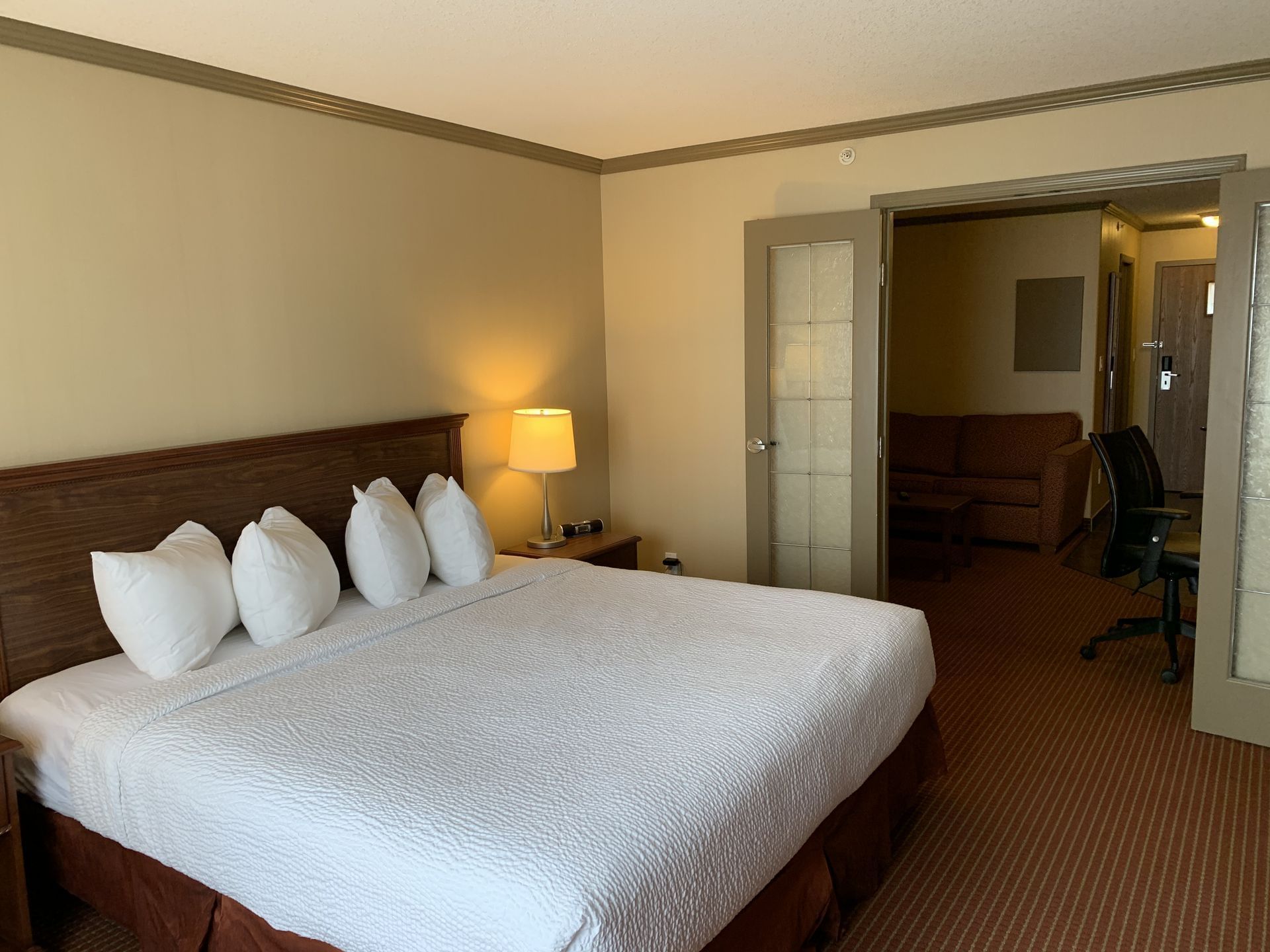 Lounge area by bedroom in Extended Stay Suite - 1 King at Merit Hotel & Suites, Fort McMurray