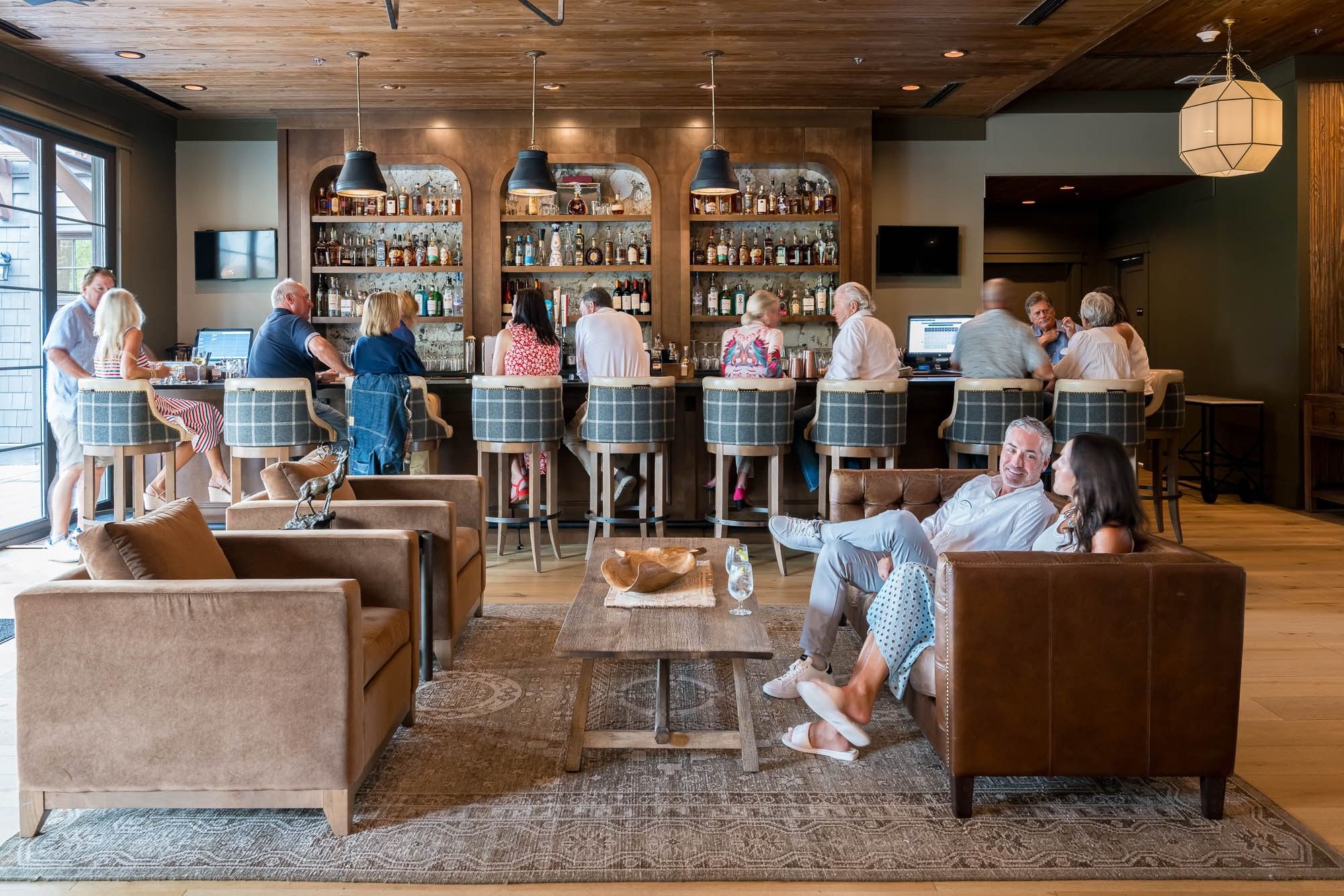 Guests enjoying drinks and conversation at Shark's Tooth bar and lounge area at Watersound Inn in Inlet Beach