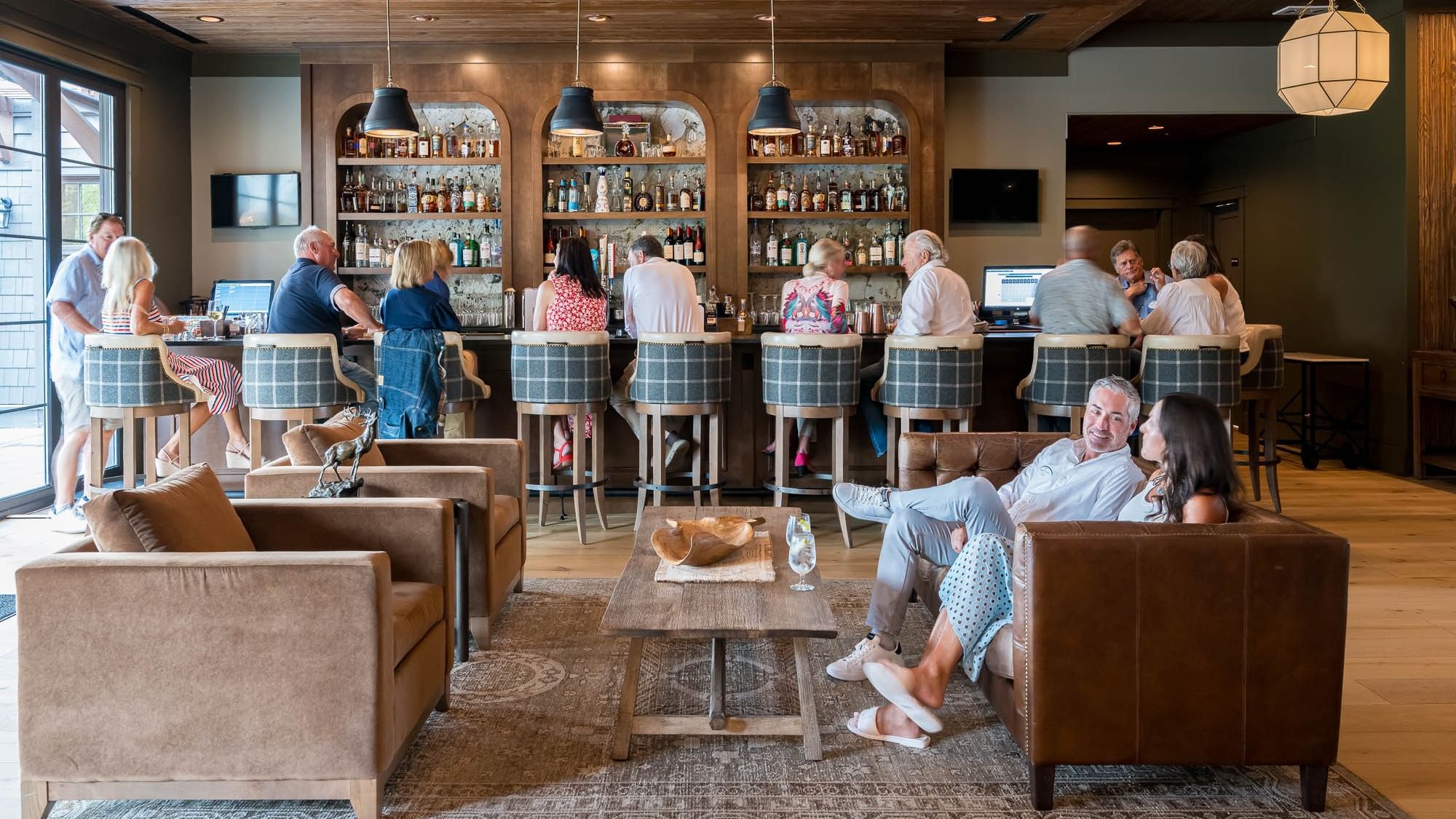 Guests enjoying drinks and conversation at Shark's Tooth bar and lounge area at Watersound Inn in Inlet Beach