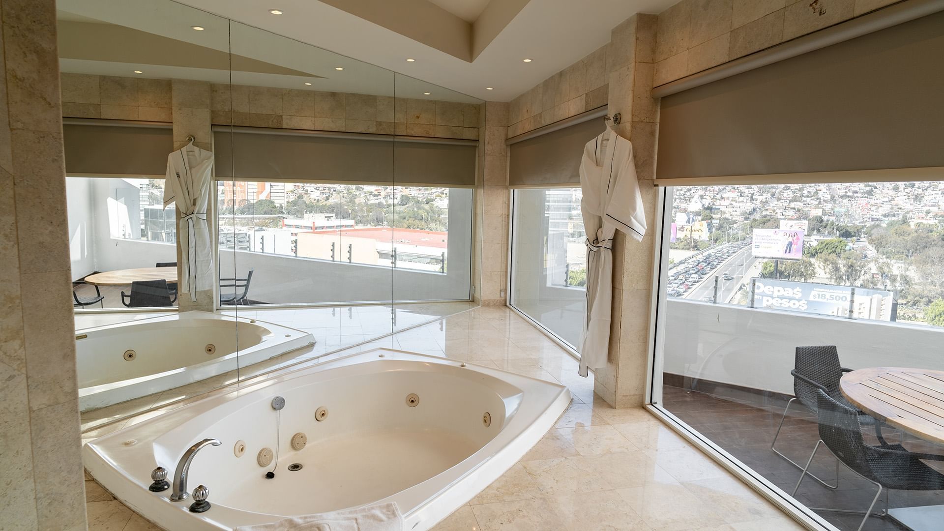 Spacious jetted soaking tub with floor-to-ceiling windows and city views in the King Presidential Suite at Real Inn Tijuana
