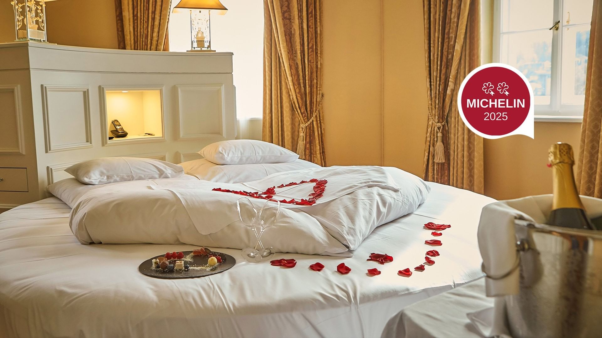 Romantic room with bed, petals, and wine at Falkensteiner Schlosshotel Velden