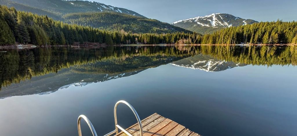 Calm waters of Lost Lake in Whistler reflecting mountains