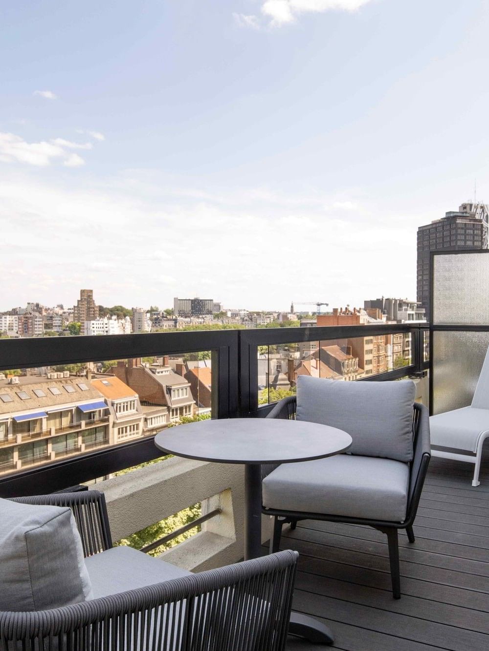 Modern balcony with lounge chairs and city view in Spring City Escape offer.