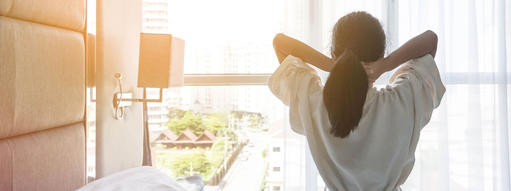 Stay Longer and Save poster with lady stretching on the bed in the background at The Independent