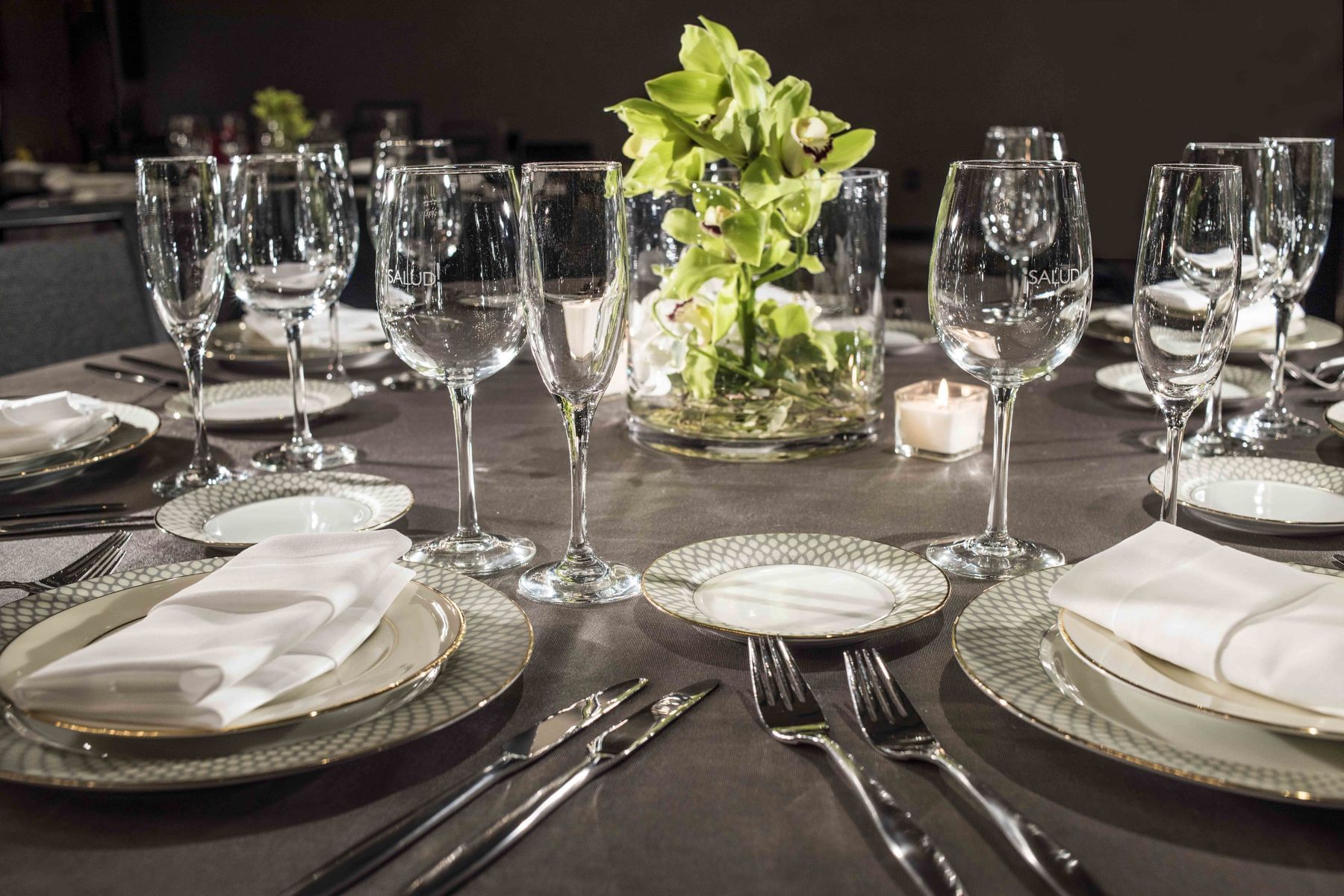 Formal place settings and floral arrangement on banquet table