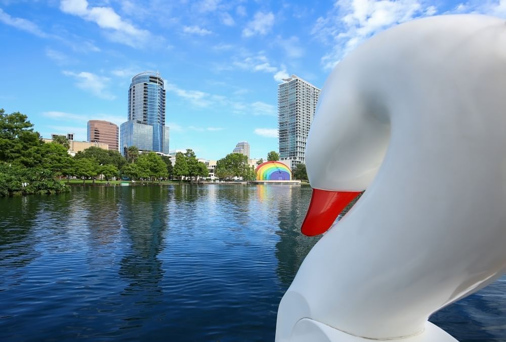 A view of downtown Orlando from Lake Eola with a large swan boat in the foreground.