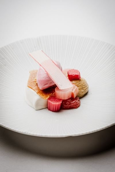 Plated dessert featuring pink rhubarb and cream served at The Capital Hotel, Apartments and Townhouse