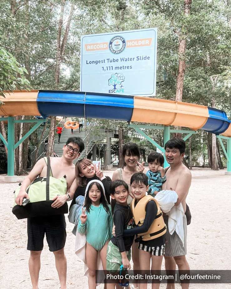 A group of people was taking a picture with Escape Penang Theme Park's longest tube water slide - Lexis Suites Penang