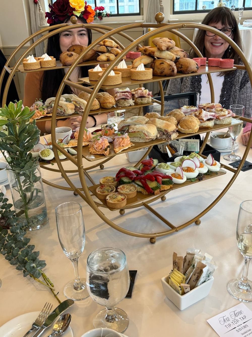 Two women enjoying Sunday Afternoon Tea with assorted pastries at Warwick Allerton Chicago.