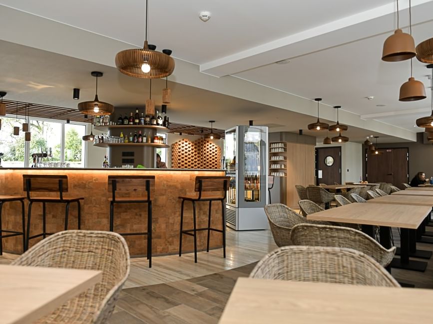 Bar et salle à manger élégants avec des tables et des chaises au Hôtel Rivella.