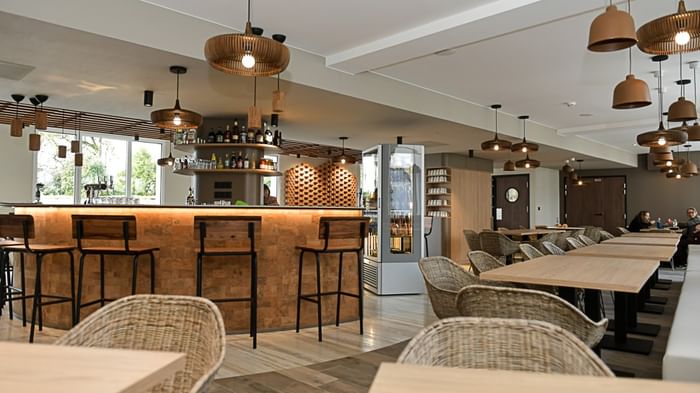 Bar et salle à manger élégants avec des tables et des chaises au Hôtel Rivella.