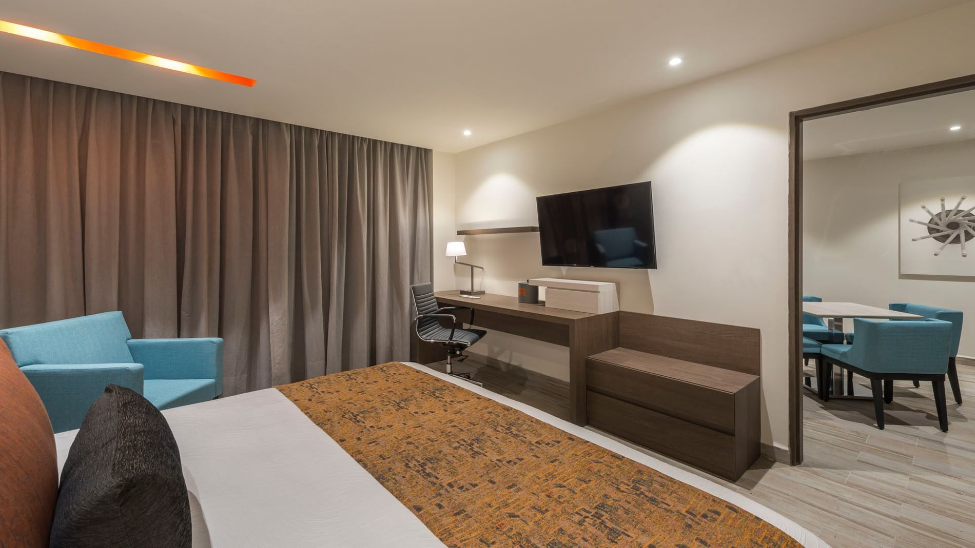 King Master Suite with a large TV, office desk, and a peek into a private dining area at Real Inn Celaya