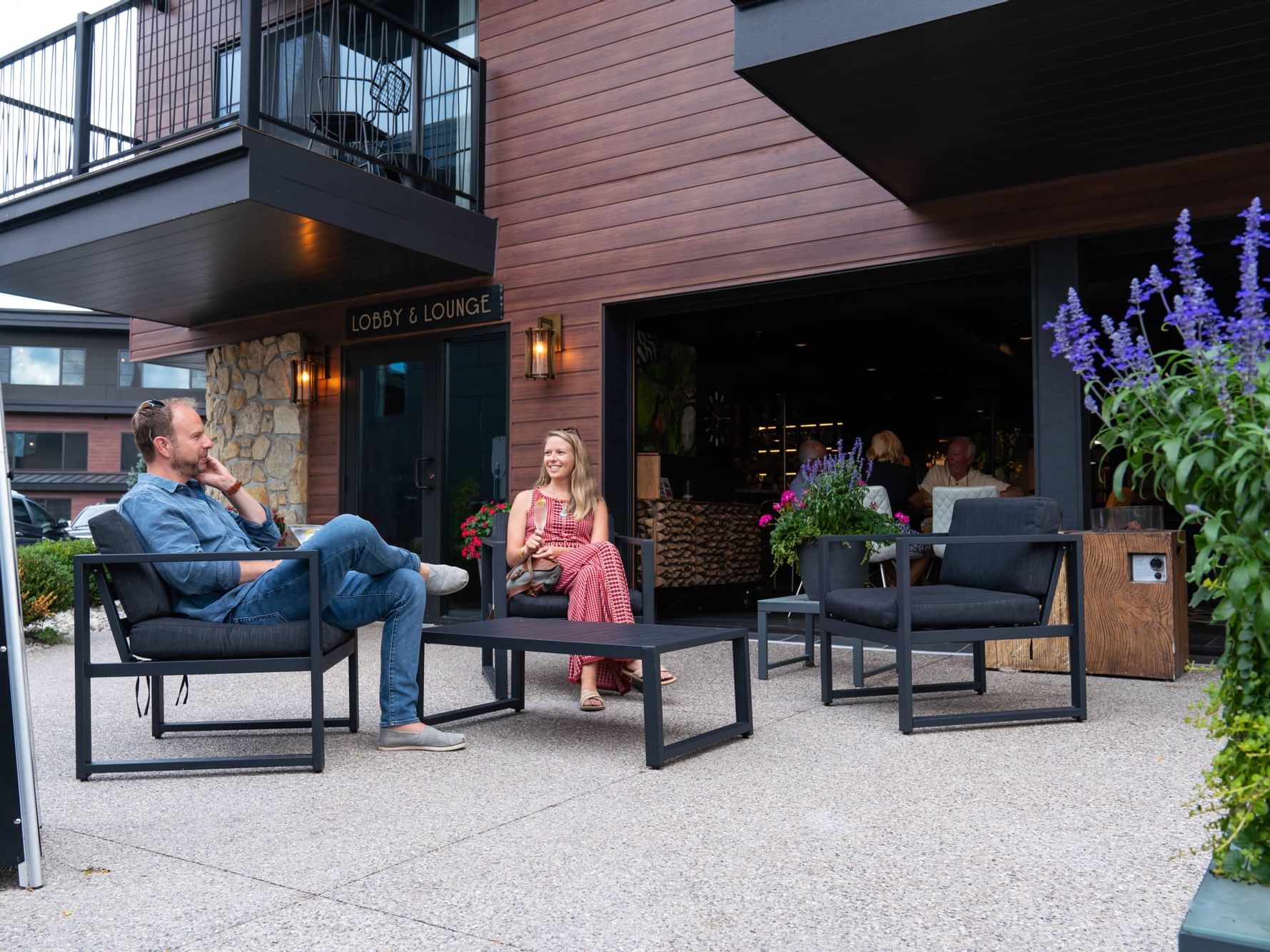 Couple enjoying drinks on the patio with arranged seating in LO Bar at The Earl