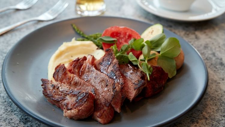 A plate of meat and vegetables served in a Restaurant at Fiesta Americana