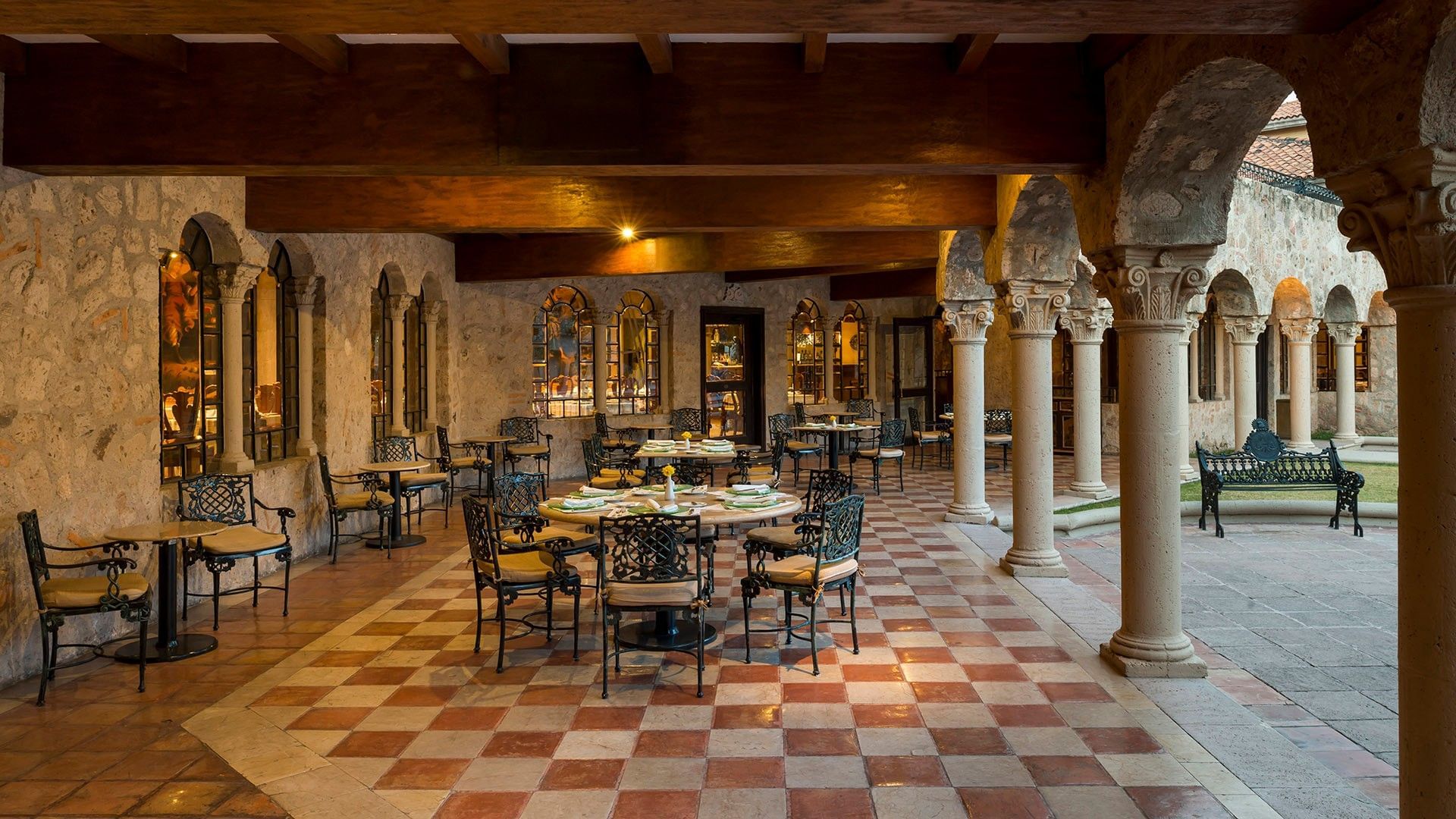 Elegant restaurant with stone arches, checkered tile floors, and wrought iron dining tables at Quinta Real Aguascalientes