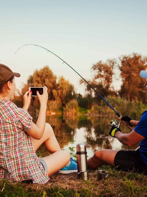 Couple fishing by a lake at sunset near Cove Pocono Resorts