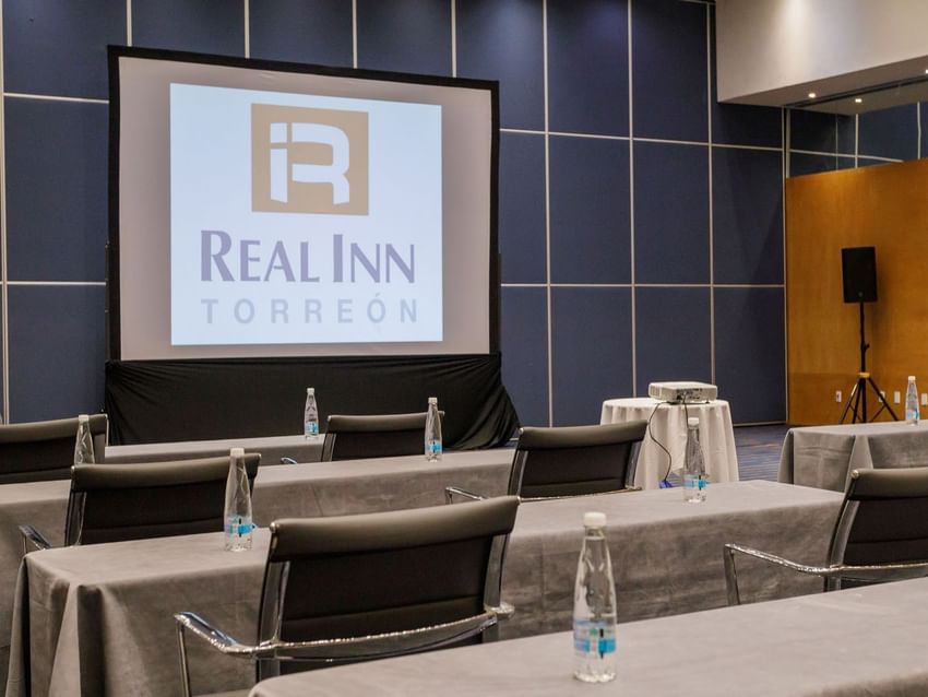 Londres event room setup with projector and water bottles at Real Inn Torreon in Torreon.