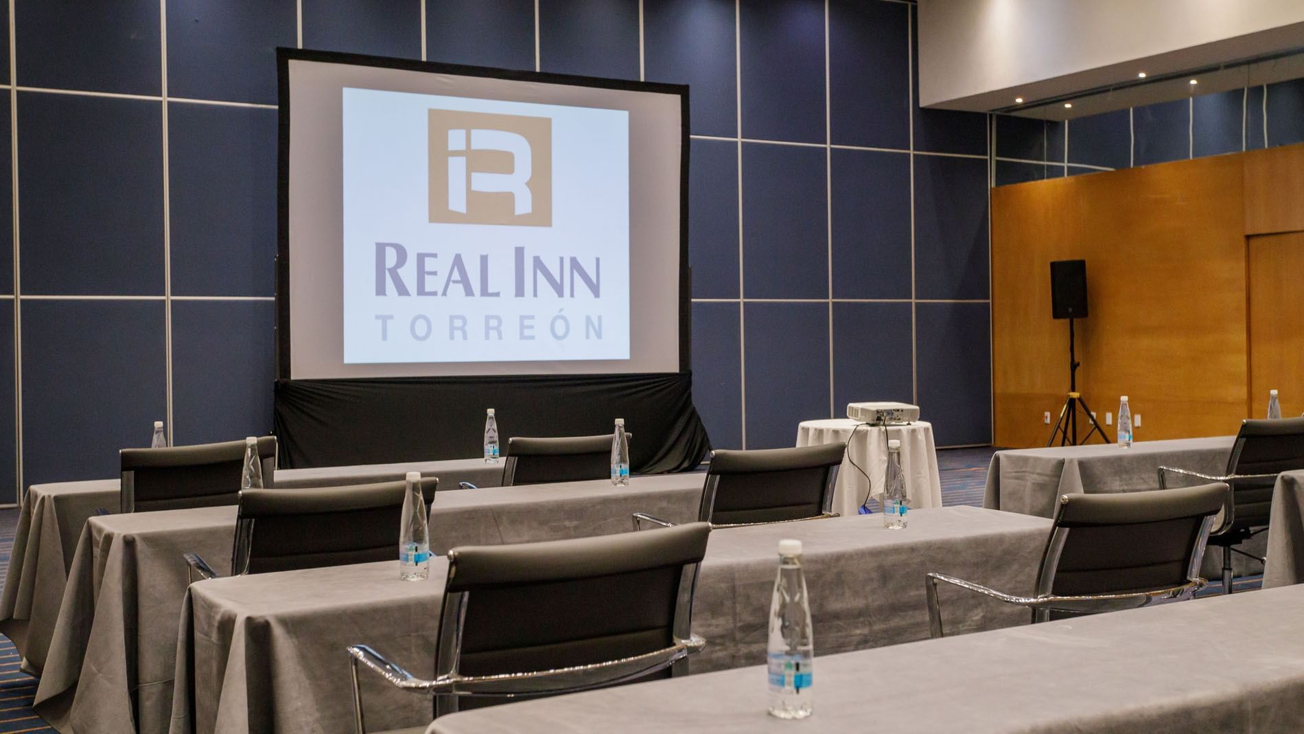 Salón Londres en Real Inn Torreón con mesas y sillas en Torreón.