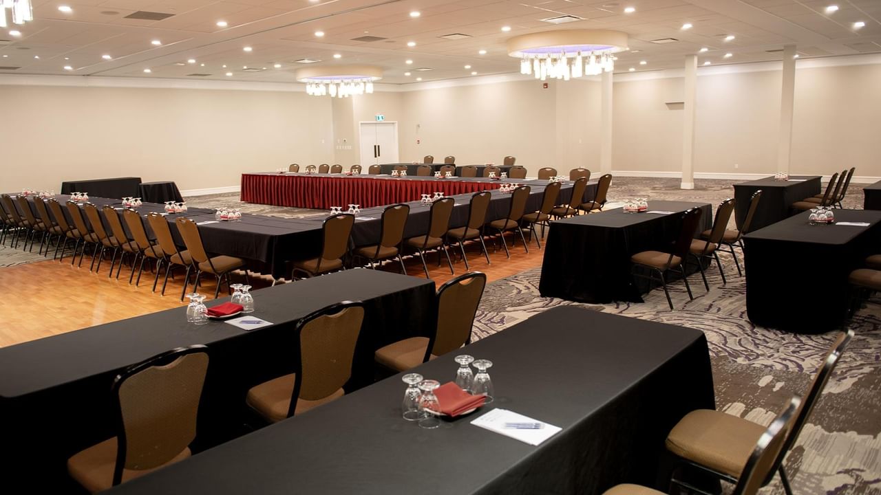 Conference room setup with multiple tables and chairs at Coast Nisku Inn & Conference Centre.