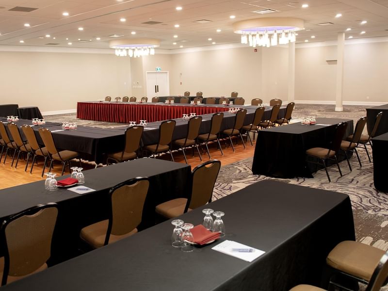 Conference room setup with multiple tables and chairs at Coast Nisku Inn & Conference Centre.