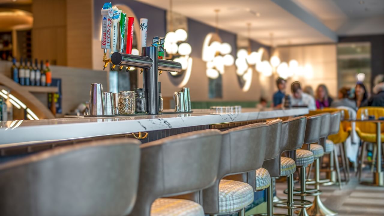 Bar with white marble counter, stools, and beer taps.