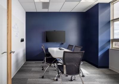 Meeting room with a long table and chairs, a whiteboard, and a TV at Aramark Ross