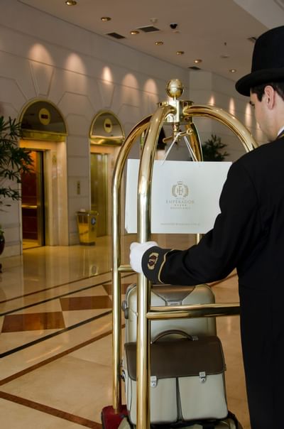 Concierge pushing a luggage cart at Hotel Emperador