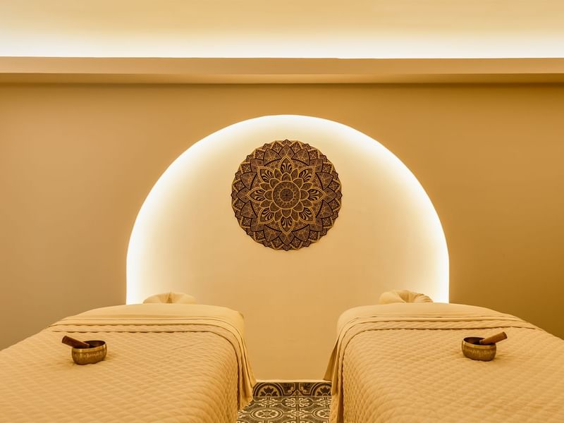 Relaxing spa treatment room at Fiesta Americana, with two massage beds and ambient, warm lighting