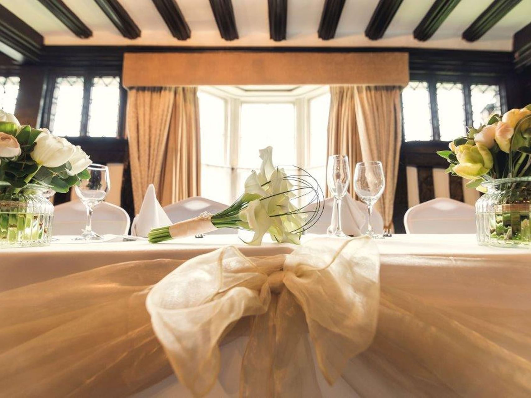 Elegantly set table at Marygreen Manor, prepared for a wedding reception with white linens and a floral centerpiece