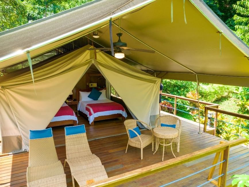 Lounge area on wooden deck by the beds in Tent Suite 2 Double Beds at Isla Chiquita Glamping Hotel