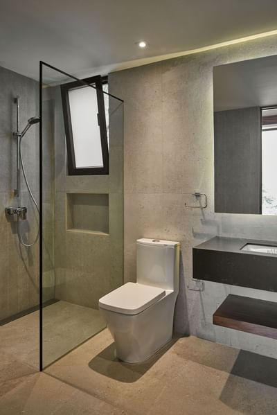 Sleek, minimalist bathroom with a shower, a modern toilet, and a black floating vanity at Singular Signature Residences