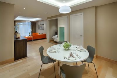 spacious living area with round dining table and four chairs