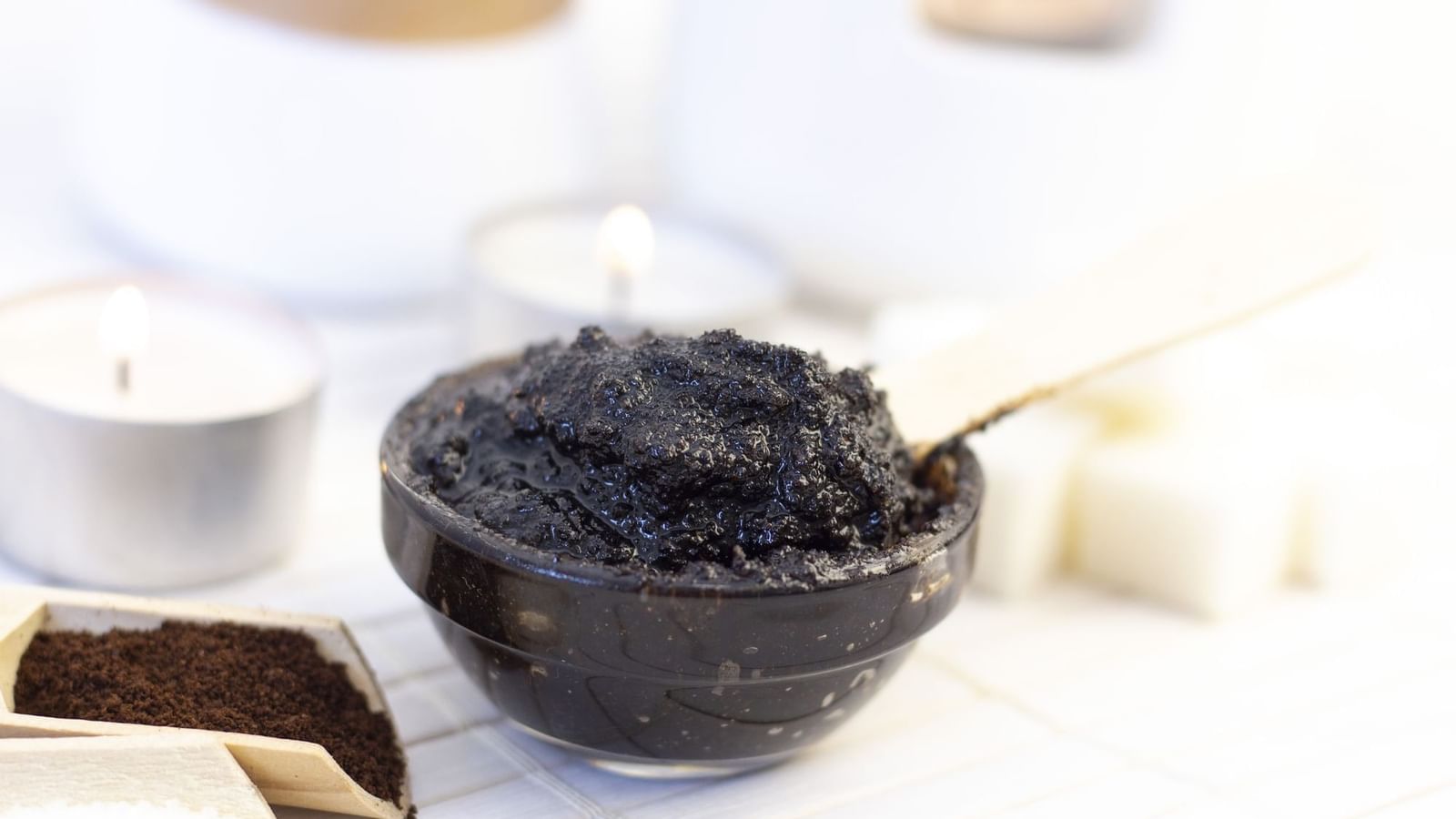 Dark scrub in a bowl with coffee grounds under warm candles at Warwick Paradise Island Bahamas