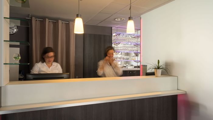 A receptionist at the reception desk in Hotel Novella Premium