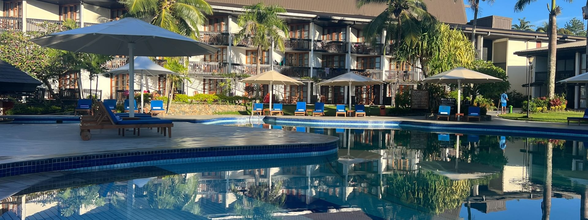 Large swimming pool with umbrellas and lounge chairs at Warwick Fiji Resort and Spa in Korolevu