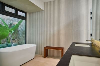 Casa Campanas bathroom with a white tub, a black double vanity, and a large window at Singular Signature Residences