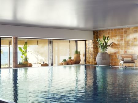 Indoor pool with ocean view and large windows for the Floating Meditation Experience.