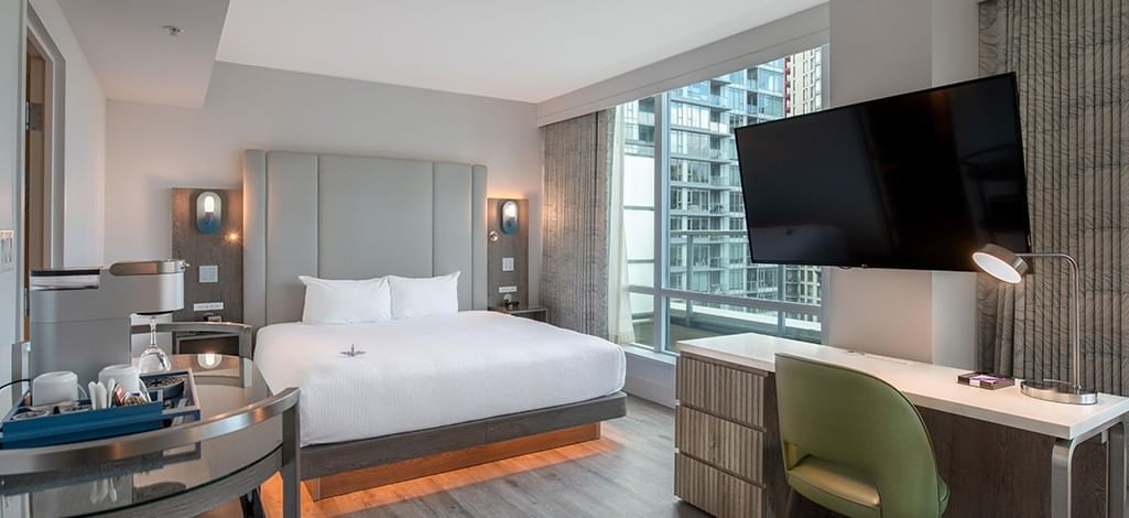 hotel room featuring a king bed, seating area and large windows
