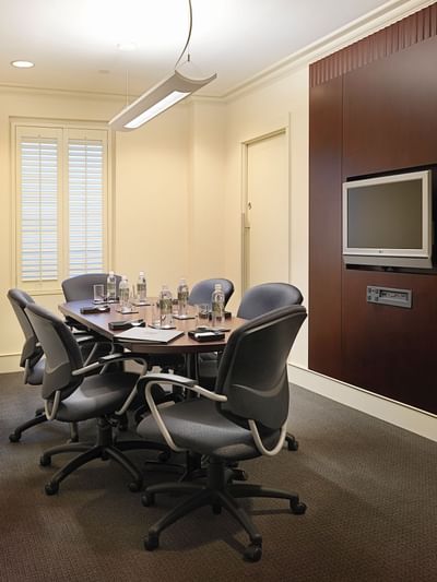 Meeting room with boardroom set-up and wall-mounted TV at The St. Regis Hotel, a boutique hotel Vancouver