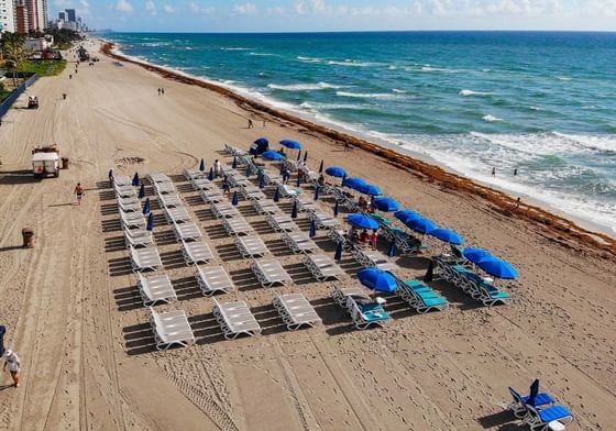Sun beds with umbrellas by the beach near Marenas Resort Miami