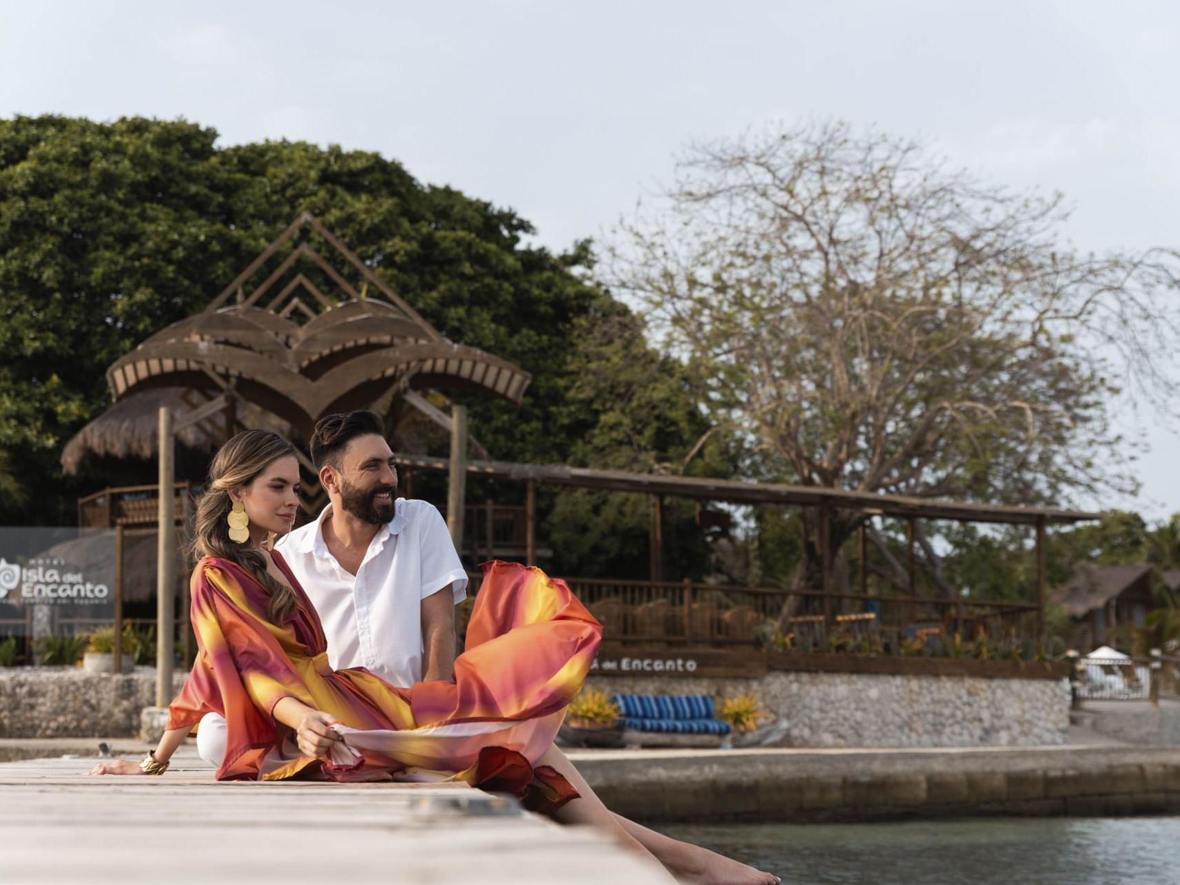 A couple enjoying beach view while sitting together on a dock at Hotel Isla Del Encanto