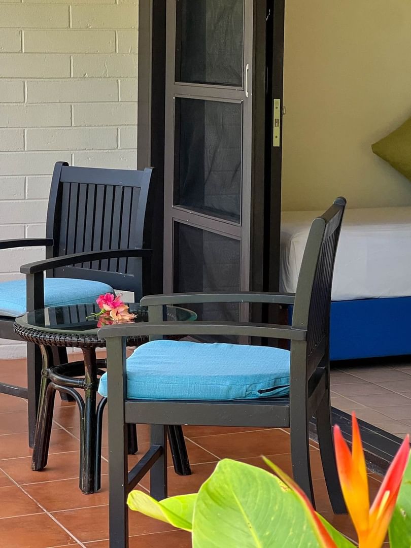 Garden View Room with two chairs, table, and tropical plants at The Naviti Resort in Korolevu.