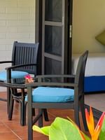 Garden View Room with two chairs, table, and tropical plants at The Naviti Resort in Korolevu.