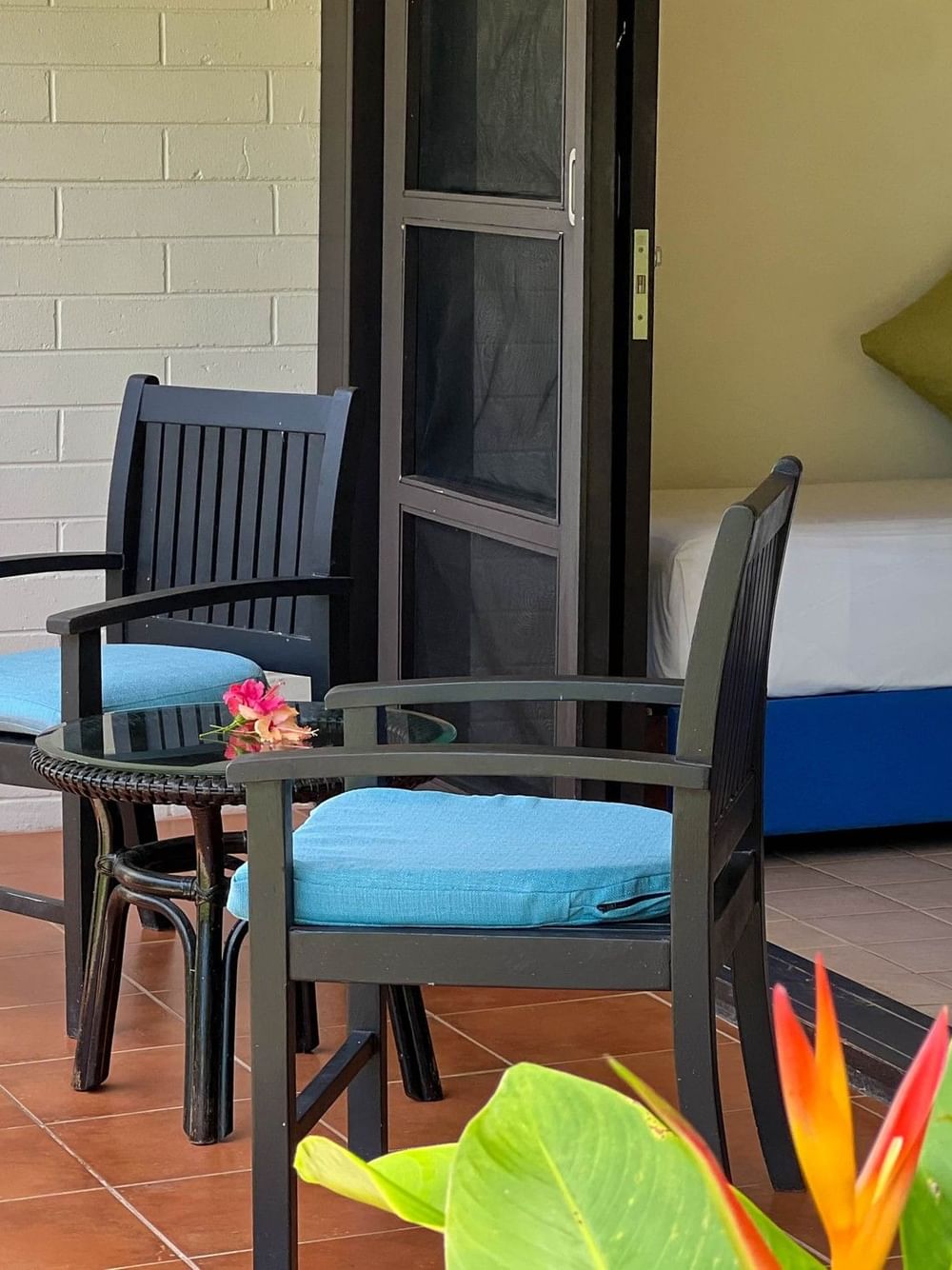Garden View Room with two chairs, table, and tropical plants at The Naviti Resort in Korolevu.