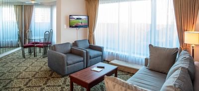 Living area of a suite at Rosedale on Robson featuring sofa, armchairs, and dining set, one of the hotel suites in Vancouver